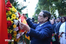 越南政府总理范明正在里约热内卢胡志明主席纪念牌前敬献花圈。(图片来源:越通社)