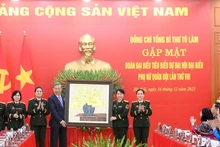 越共中央总书记苏林向出席越南人民军妇女第八次代表大会的先进模范代表赠送礼物。