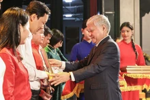 越南祖国阵线中央委员会主席杜文战向"越南-古巴情谊65周年"支持古巴人民募捐活动的优秀集体和个人颁奖。