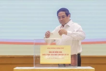 政府总理范明正为遭受第十号台风影响的灾民捐款。（图片来源：越通社）
