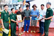 芹苴市边防部队指挥部向渔民赠送国旗和胡伯伯的照片。（图片来源：越通社）