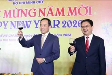 越共中央政治局委员、胡志明市市委书记陈流光（左）与出席活动的来宾举杯共庆新年。（图片来源：越通社）