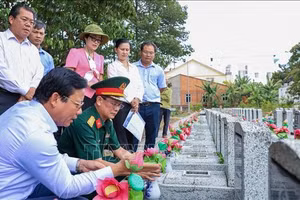 西宁省人民委员会副主席范晋和（左一）与工作团在安静烈士陵园（西宁省安静坊）核查无名烈士墓信息。