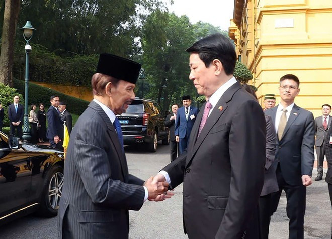 越南国家主席梁强迎接文莱达鲁萨兰国苏丹哈吉·哈桑纳尔·博尔基亚对越南进行国事访问。