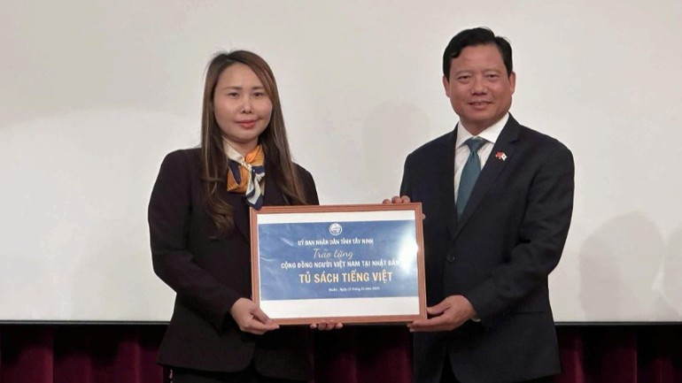 西宁省人民委员会副主席范晋和向旅居关西地区的越南人社群赠送“越南书柜”。