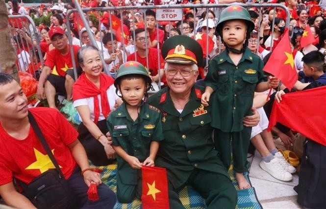 尽管等待辛苦,但所有人都沉浸在民族的喜悦中,期待看到阅兵、游行方队在民众和祖国的欢呼中昂首前行。(图片来源:越通社) vna-potal-nguoi-dan-ha-noi-hao-huc-cho-don-tong-hop-luyen-dieu-binh-dieu-hanh-a80-lan-thu-2-8231337.jpg