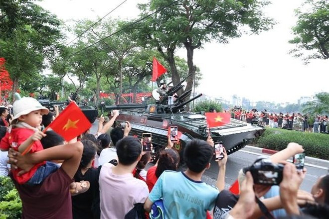 尽管天气时而酷热、时而大雨,民众仍耐心等待。(图片来源:越通社) vna-potal-cac-luc-luong-san-sang-cho-tong-hop-luyen-dieu-binh-dieu-hanh-a80-lan-thu-2-8231418.jpg