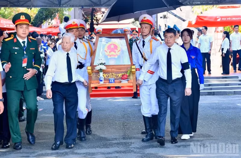 政府总理黎明兴与原越共中央政治局委员、原国家主席阮明哲及各位代表送烈士遗骸离开黎氏莲公园。