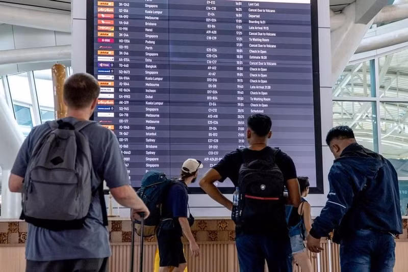 旅客在印度尼西亚巴厘岛伍拉·赖国际机场查看电子显示屏上的信息。（图片来源：新华社）