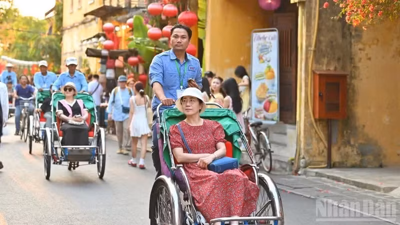 游客乘坐三轮车游览会安古镇。
