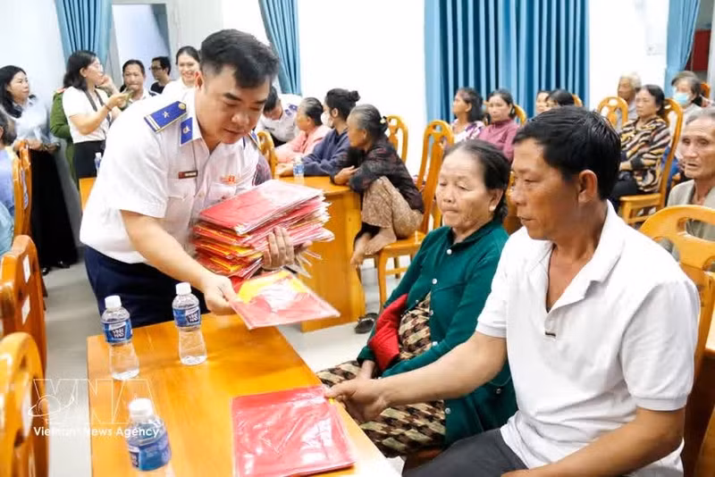 海警第3区司令部工作团向渔民赠送国旗。（图片来源：越通社）