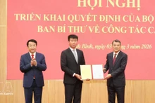 越共中央政治局委员、中央书记处书记、中央组织部部长黎明兴向陈辉俊同志颁发决定。（图片来源：越通社）