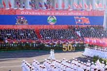附图：纪念老挝国庆50周年的阅兵游行活动。（图片来源：越通社）