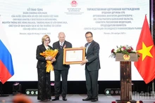 越南驻俄罗斯大使邓明魁向俄罗斯联邦委员会预算与金融市场委员会主席、卡卢加州前州长长阿纳托利·阿尔塔莫诺夫授予友谊勋章。（春兴 摄）