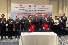 岘港市人民委员会主席范德印与法兰克福金融公司代表签署金融中心合作谅解备忘录。（图片来源：丁强 摄）