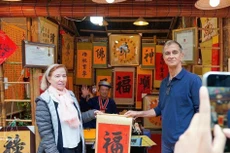 国际游客体验年初“求字”活动。（图片来源：越通社）