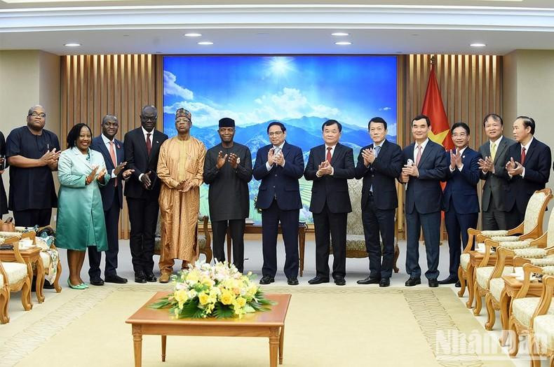 越南政府总理范明正、尼日利亚副总统耶米同两国代表团成员合影。