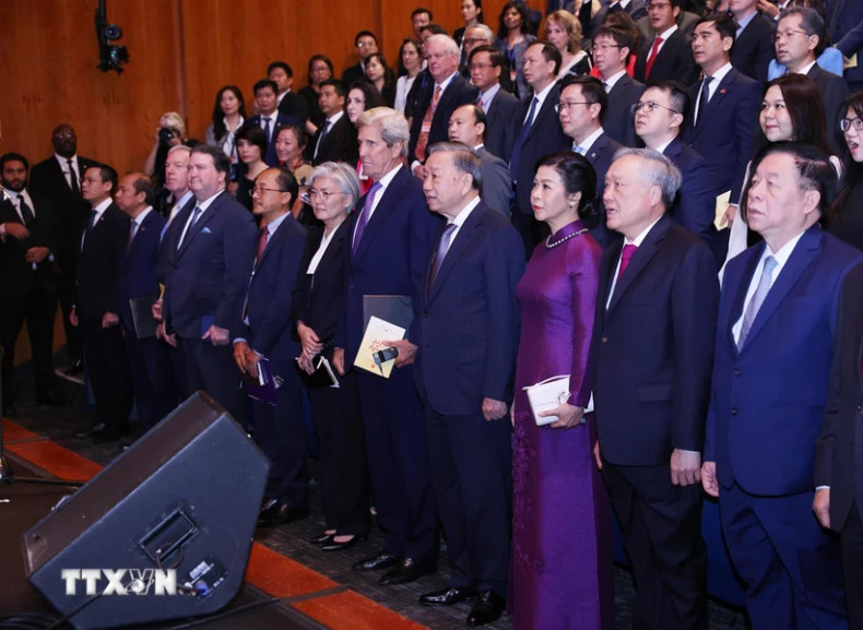 越共中央总书记、国家主席苏林同夫人和各位代表唱起越南国歌。（图片来源：越通社）