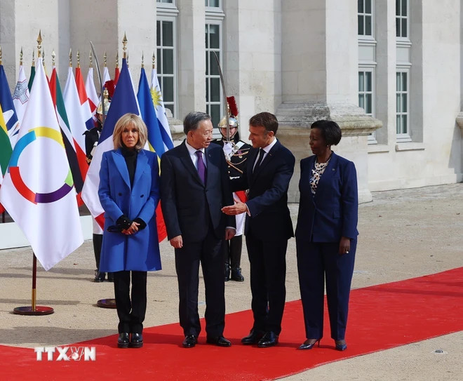 法国总统埃马纽埃尔·马克龙和法语国家国际组织秘书长路易丝·穆希基瓦博欢迎苏林总书记、国家主席的到来。（图片来源：越通社）