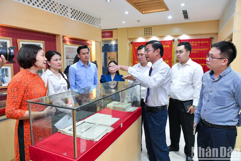 老挝《人民报》社代表团参观越南《人民报》社传统展示厅。