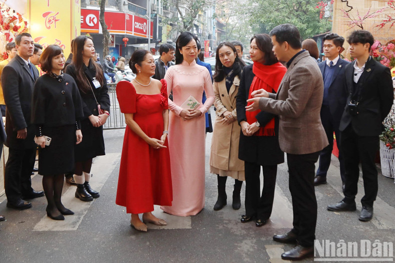 越南国家主席夫人和菲律宾总统夫人倾听有关梳街传统花市的介绍。 越南国家主席夫人和菲律宾总统夫人倾听有关梳街传统花市的介绍。