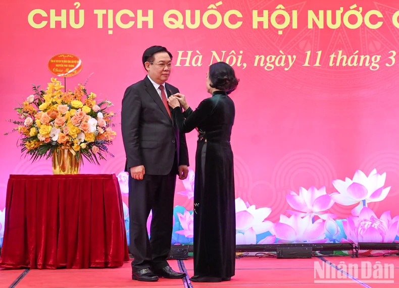 越共中央政治局委员、中央书记处常务书记、中央组织部部长张氏梅向国会主席王廷惠颁发40周年党龄纪念章。