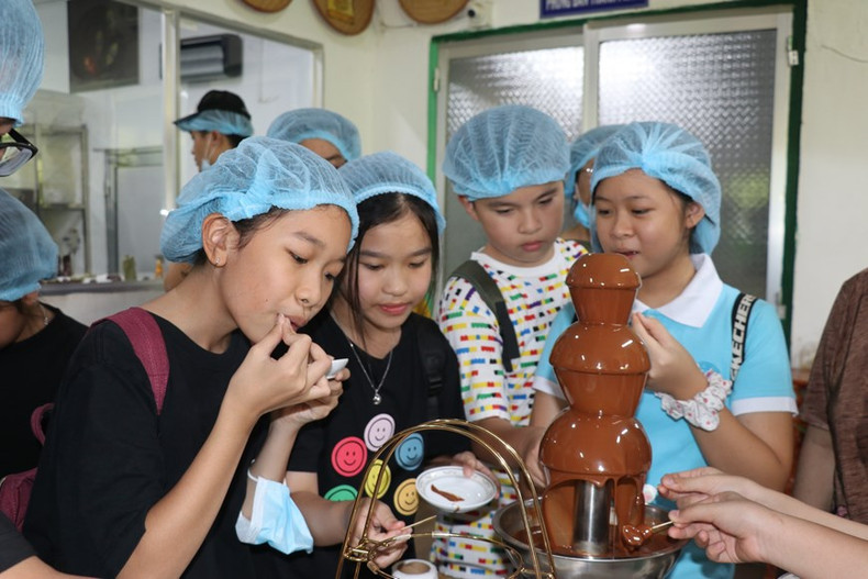 小朋友们品尝在𢄂𥺊春伦可可有限公司生产的生鲜巧克力。