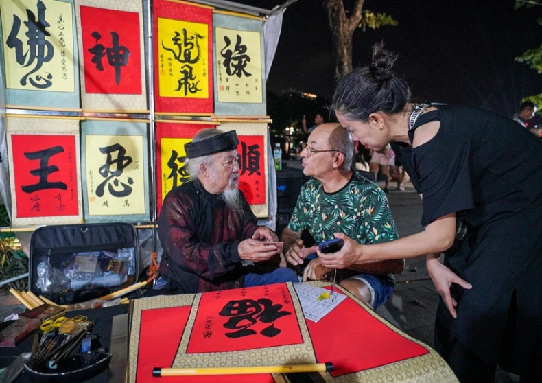 外国游客在还剑湖步行街求字。 外国游客在还剑湖步行街求字。