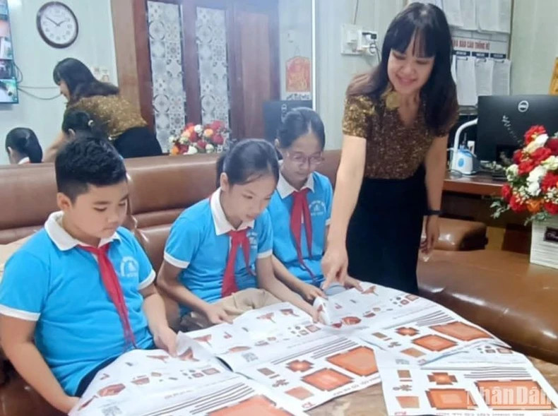 太平省武书镇小学学校师生了解由《人民报》赠送的“河内旗台”副版。 太平省武书镇小学学校师生了解由《人民报》赠送的“河内旗台”副版。