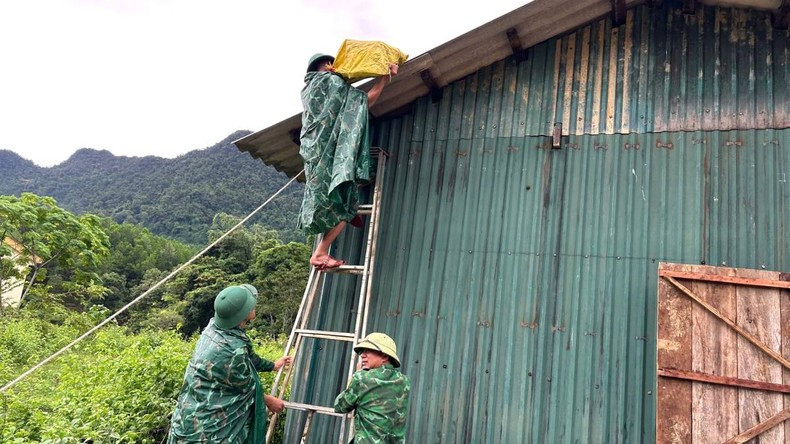 伽向边防哨所的干部和战士帮助明化县上化乡的人民在屋顶上放置沙袋,以防止强风和暴风雨掀翻屋顶。 伽向边防哨所的干部和战士帮助明化县上化乡的人民在屋顶上放置沙袋,以防止强风和暴风雨掀翻屋顶。