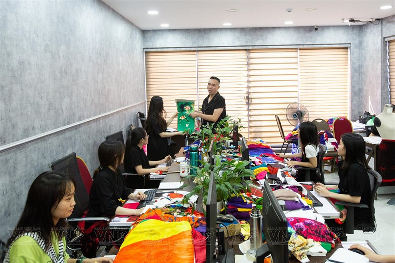 设计师杜郑淮南向员工传授奥黛设计和缝纫技术。