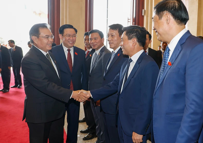 越南国会主席王廷惠向老挝国会主席赛宋蓬·丰威汉介绍越南国会代表团的成员。