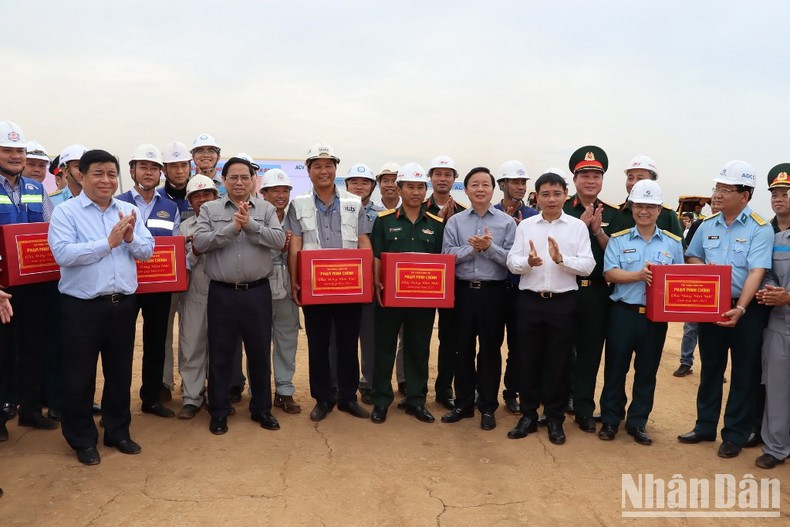 越南总理范明正在龙城机场建设投资项目施工现场向工人们赠送礼物并预祝新年快乐。