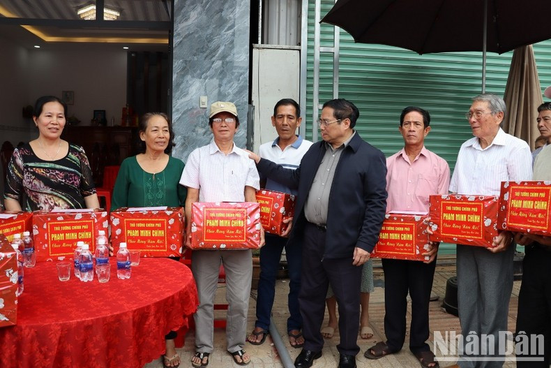 范明正总理向同奈省龙城县禄安-平山安置区人民赠送礼品。