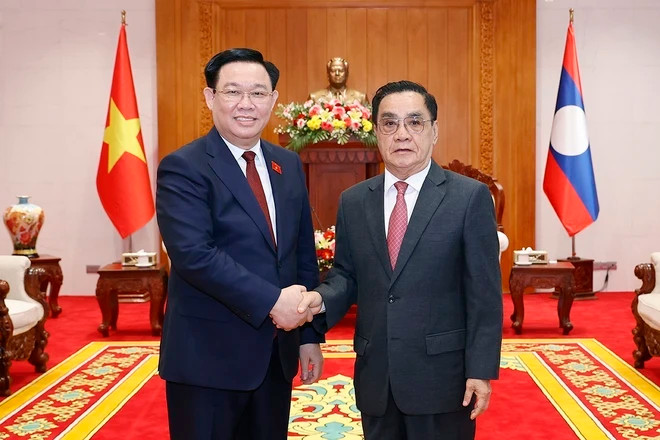 国会主席王庭惠与老挝前政府总理通辛•坦马冯以及两国代表合影。