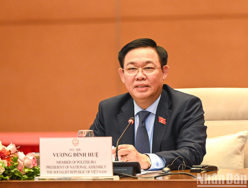 国会主席王廷惠同企业代表交谈。