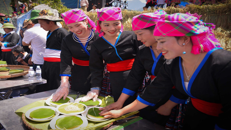 人们用香蕉叶把被舂至绵软柔韧的糯米饭按圆形包起来。 人们用香蕉叶把被舂至绵软柔韧的糯米饭按圆形包起来。