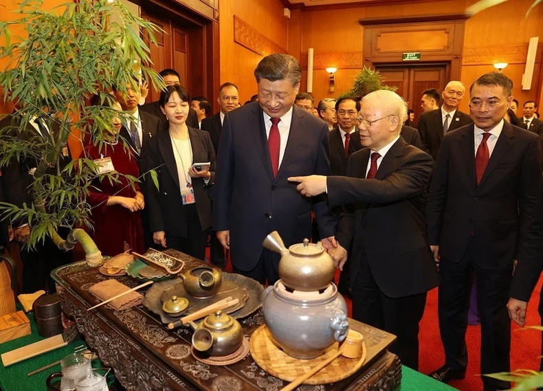 越共中央总书记阮富仲和中共中央总书记、中国国家主席习近平听取茶道文化的介绍。(图片来源:越通社) 越共中央总书记阮富仲和中共中央总书记、中国国家主席习近平听取茶道文化的介绍。(图片来源:越通社)