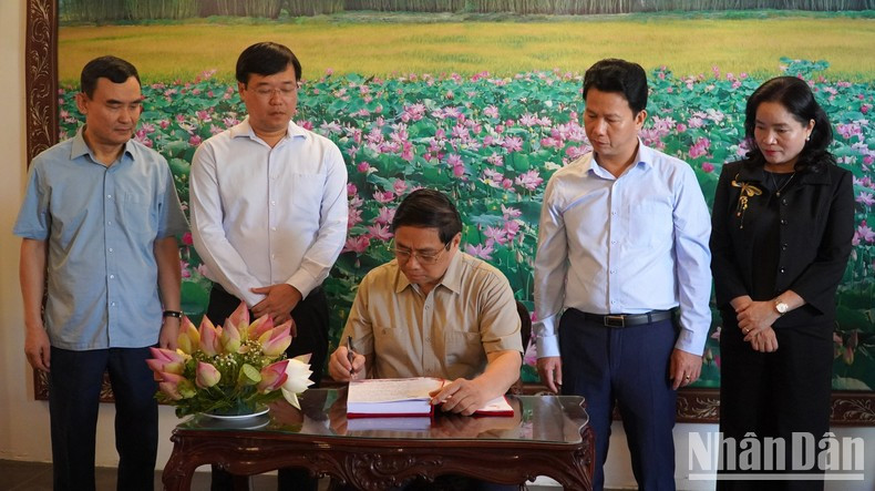 范明正总理在阮生色遗迹区纪念簿上留言。