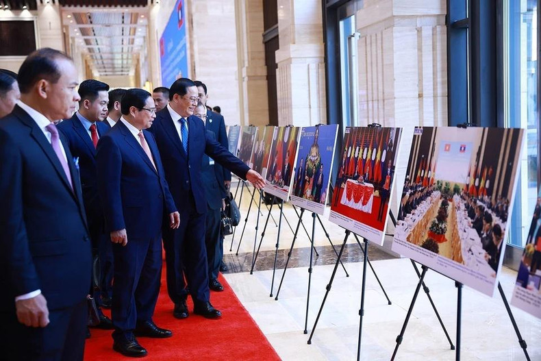 越南政府总理范明正与老挝政府总理宋赛·西潘敦共同参观两国合作图片展。