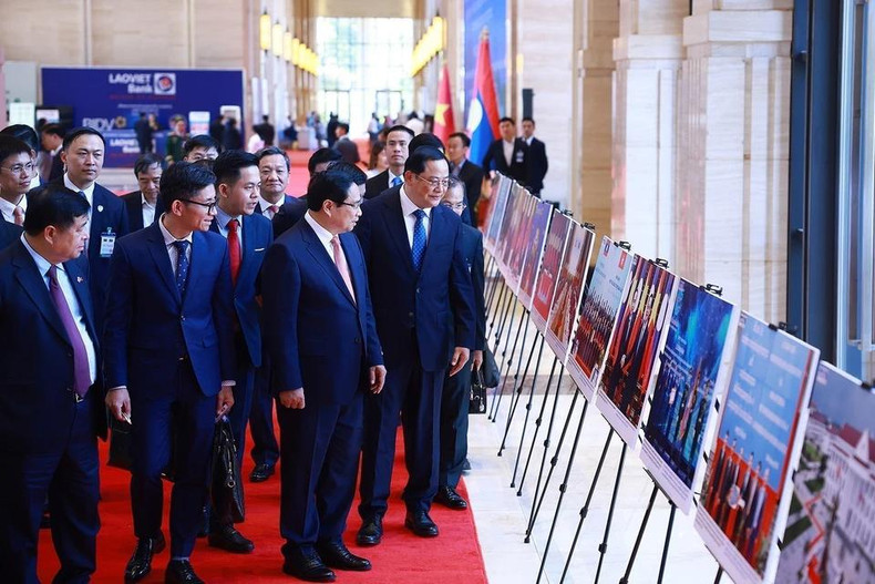 越南政府总理范明正与老挝政府总理宋赛·西潘敦共同参观两国合作图片展。