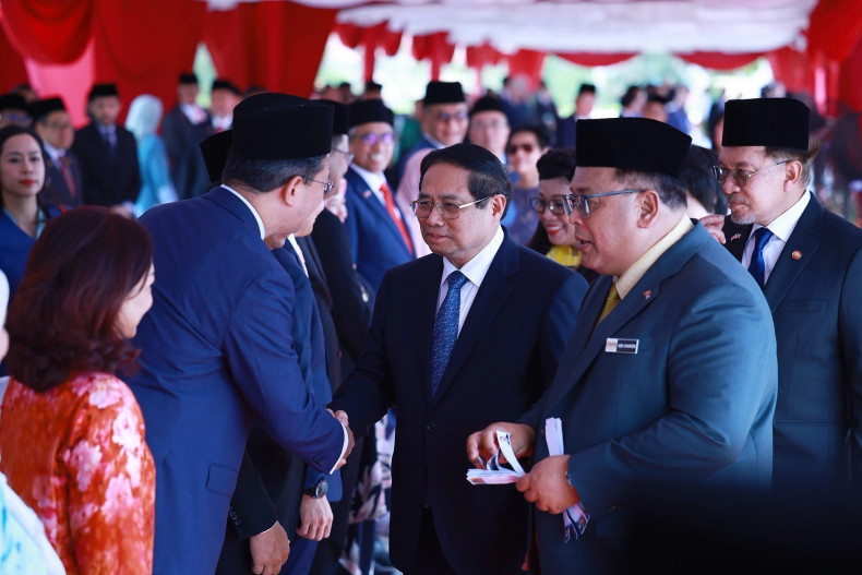 范明正总理与马来西亚代表团成员握手致意。