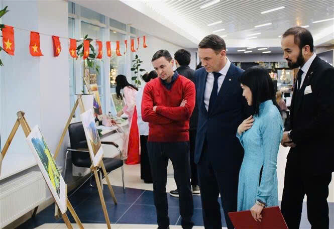 俄罗斯友人参观“越南风土人情”图片展。（图片来源：越通社）