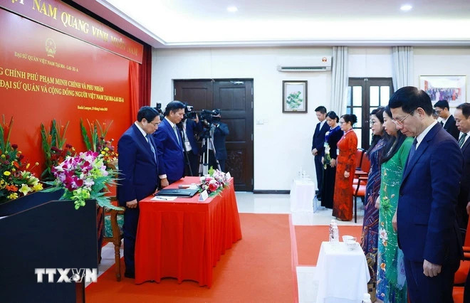 范明正总理和夫人与越南驻马来西亚大使馆工作人员以及旅马越南人社群代表一同向原国家主席陈德良默哀致敬。（图片来源：越通社）