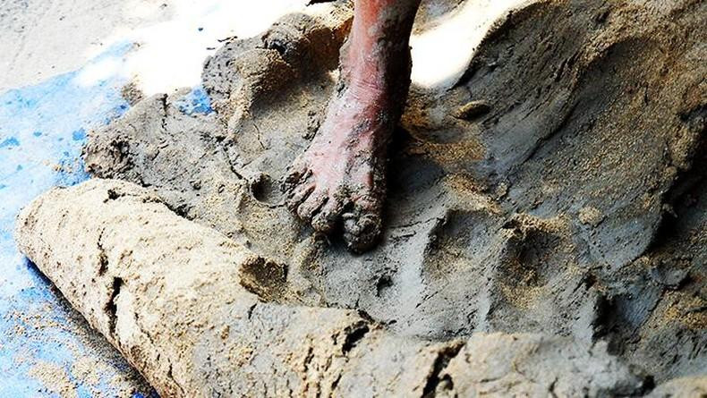 将粘土、沙子和水的成分揉在一起。