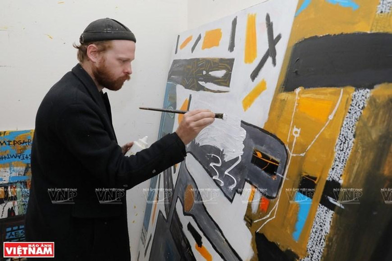 美国画家大卫埃文斯正在完善自己的绘画作品。（图片来源：越南画报）