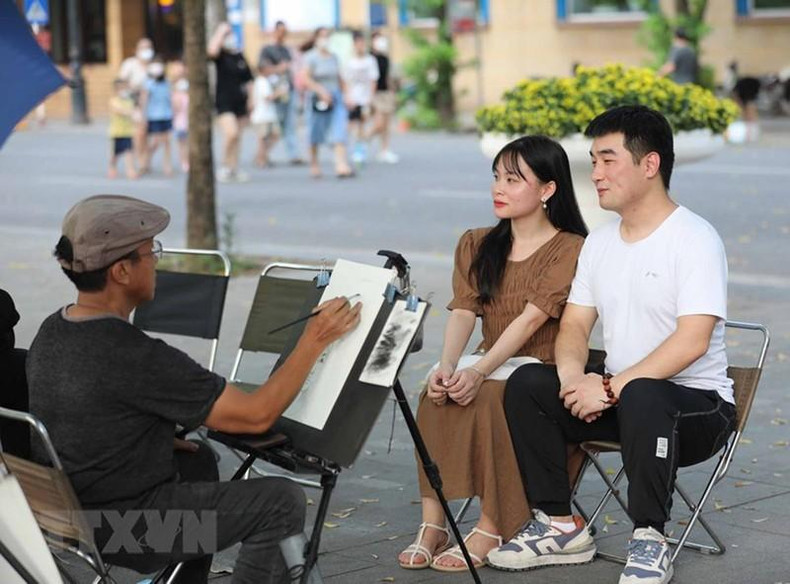 游客在还剑湖步行空间体验肖像绘画。 游客在还剑湖步行空间体验肖像绘画。