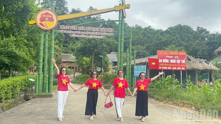 游客在宣光省新潮乡新立旅游文化村拍纪念照。