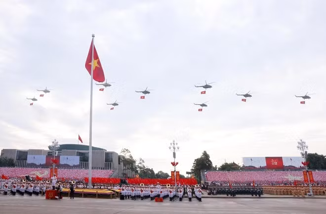 人民空军直升机编队悬挂党旗与国旗飞越河内上空。