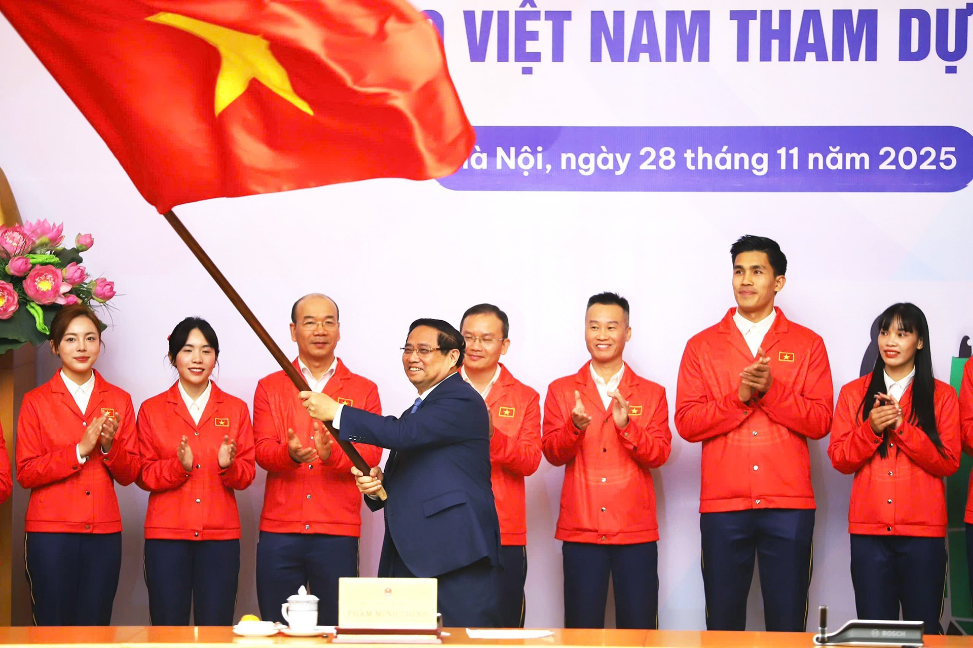 范明正总理向越南体育代表团赠送国旗。